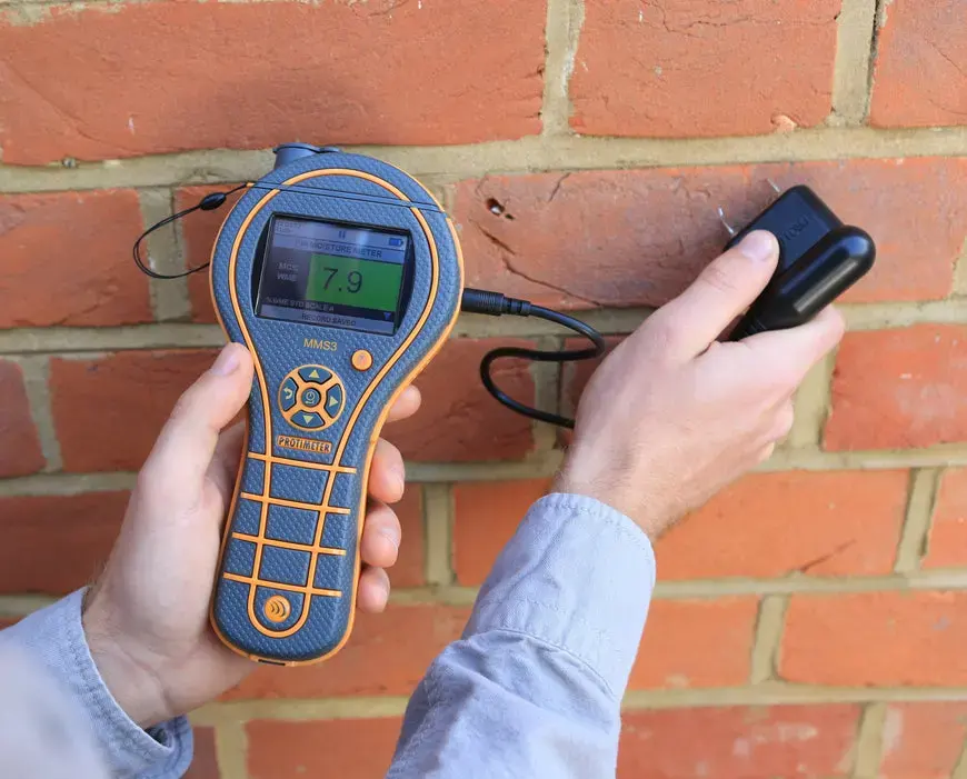 Moisture meter checking a brick wall for water after a leak in Rochester, MI
