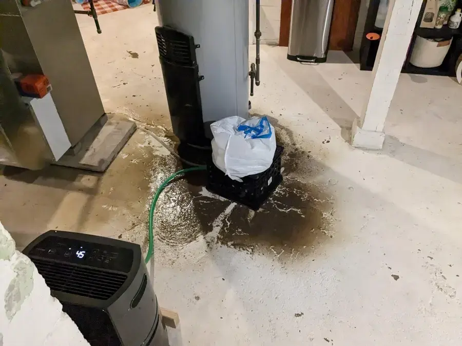 Dark water spreading from a floor drain across a basement floor in Rochester, MI
