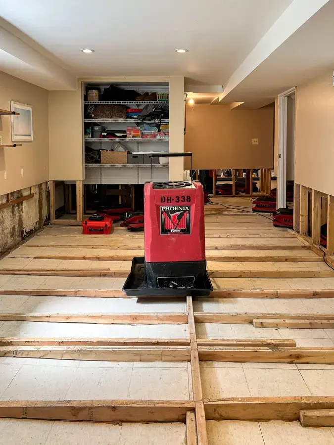 Dehumidifier drying a finished basement after flood cuts in Rochester, MI