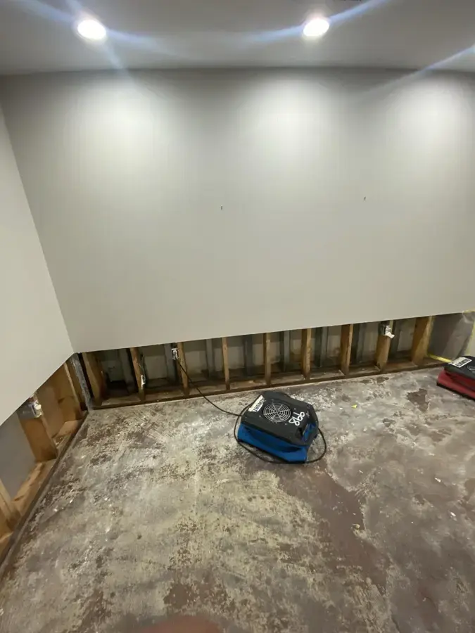 Air mover drying a basement room with the lower drywall removed in Rochester, MI