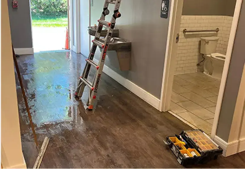 Wet commercial hallway floor outside a restroom in a Rochester, MI building