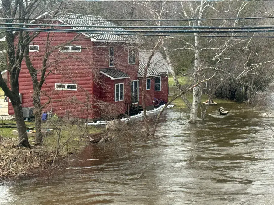 River floodwater surrounding a house during spring high water in Oakland County, MI